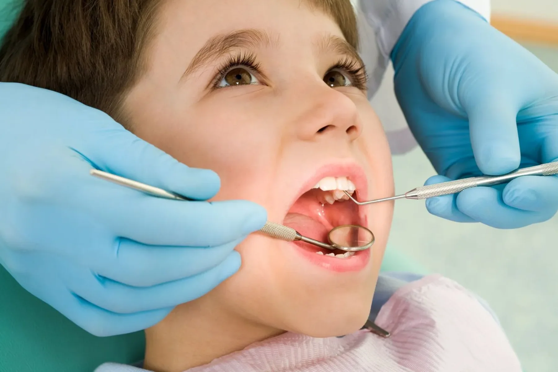 Pediatric dentist examining a young patient's teeth